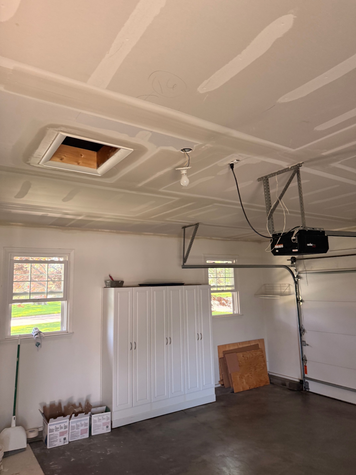 Taped and coated ceiling around the attic access — second coats going on between bays