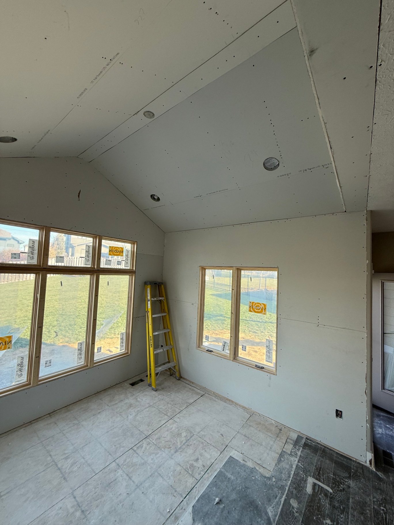 Hung walls and vaulted ceiling viewed across the room — clean transitions at every angle