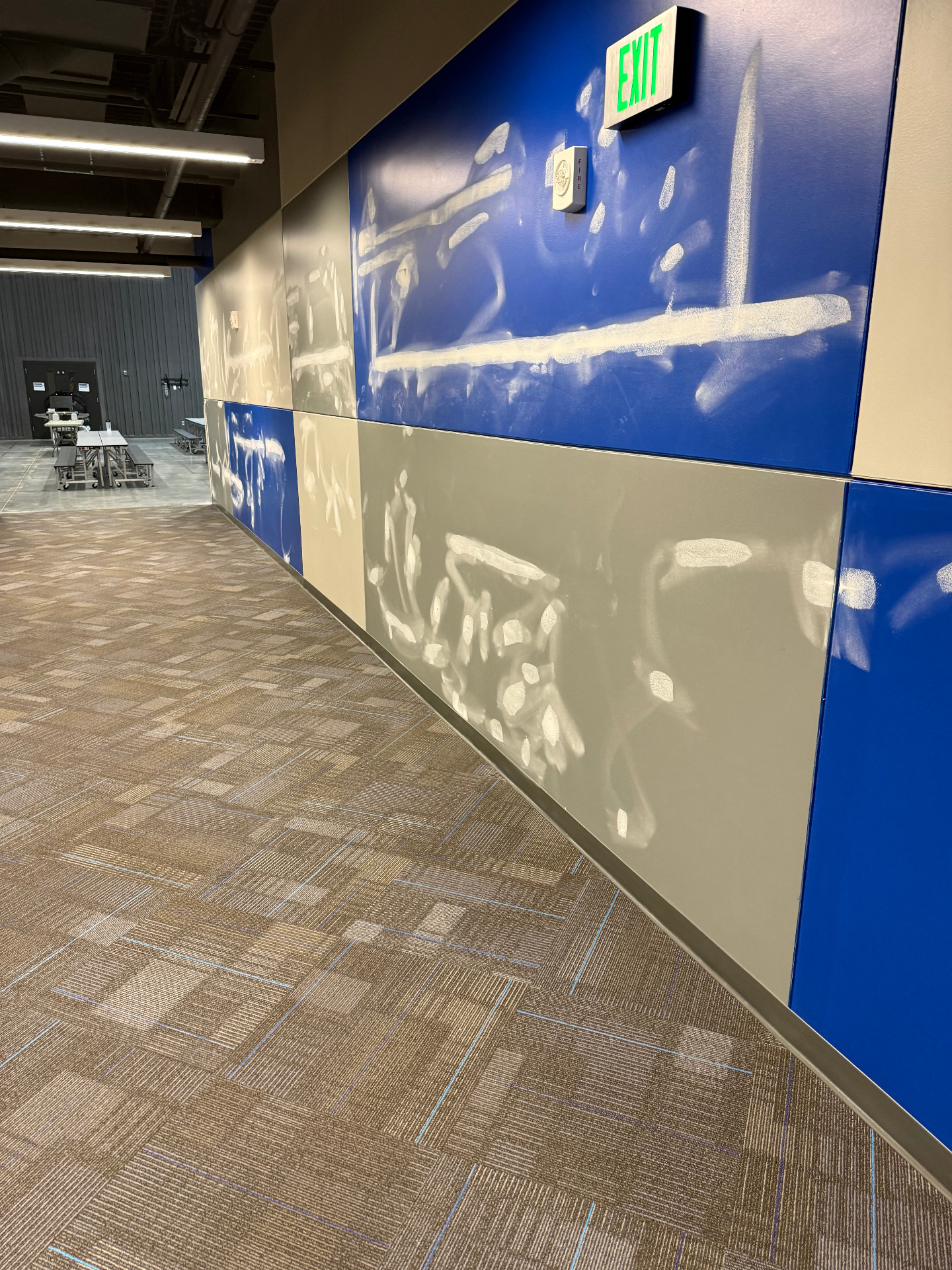Painted panel wall with surface damage spot-patched and feathered to blend into the existing blue and tan finish