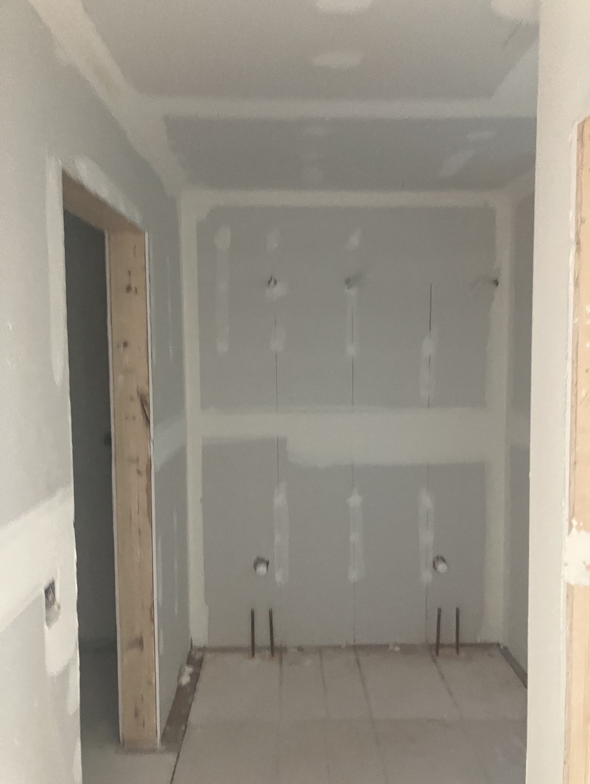 Tight closet alcove hung with new drywall and taped — ready for finish coats and paint