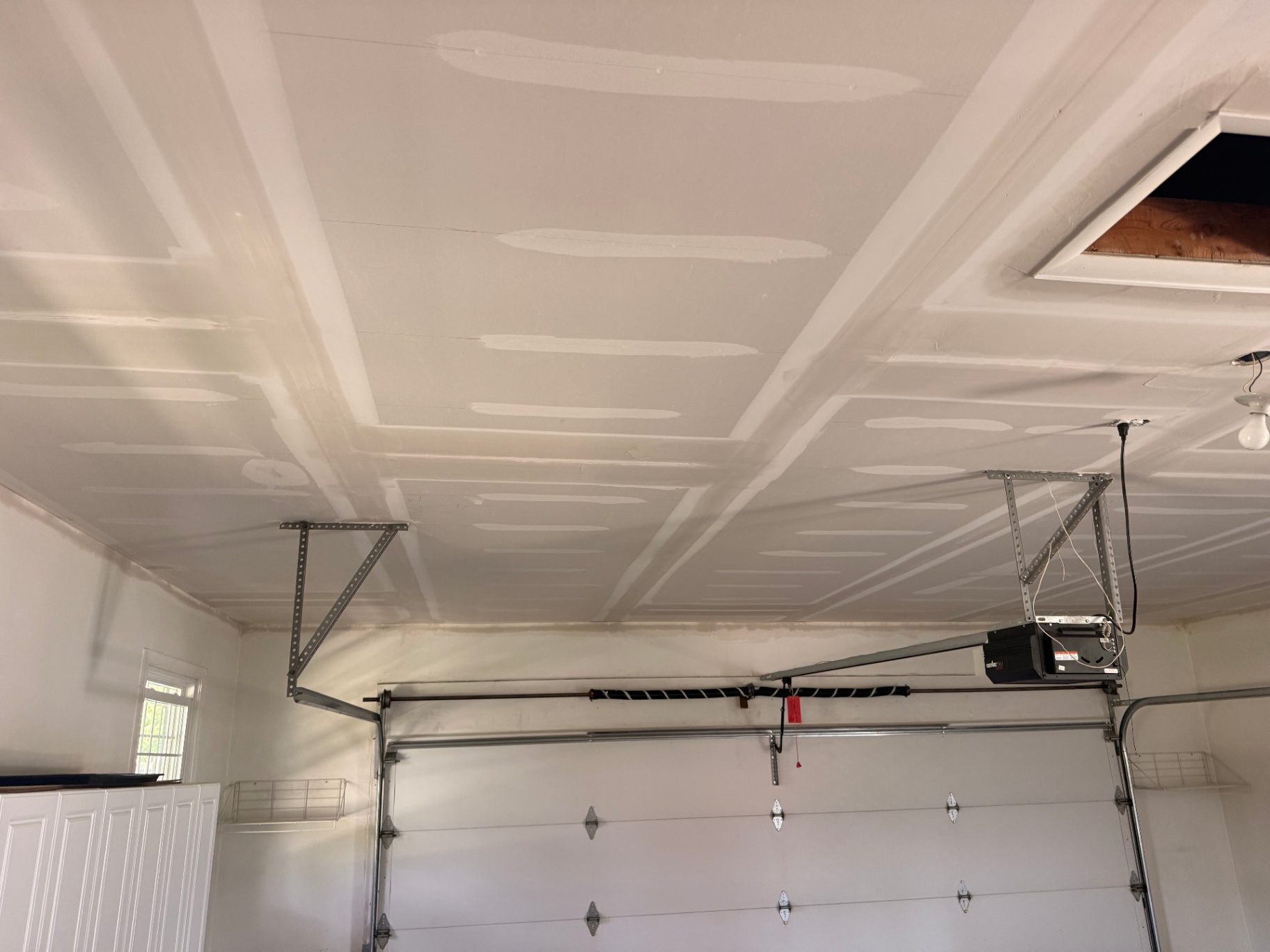 Wide angle showing the full ceiling overlay coated out from wall to wall above the garage door