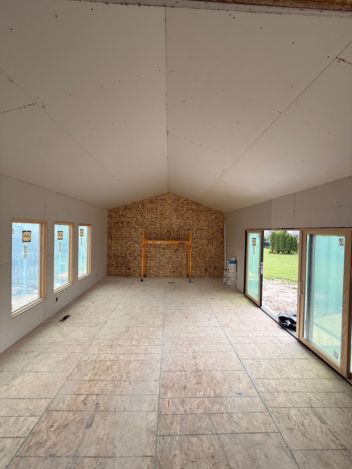 Walls and vaulted ceiling fully hung with drywall — seams ready for tape and mud