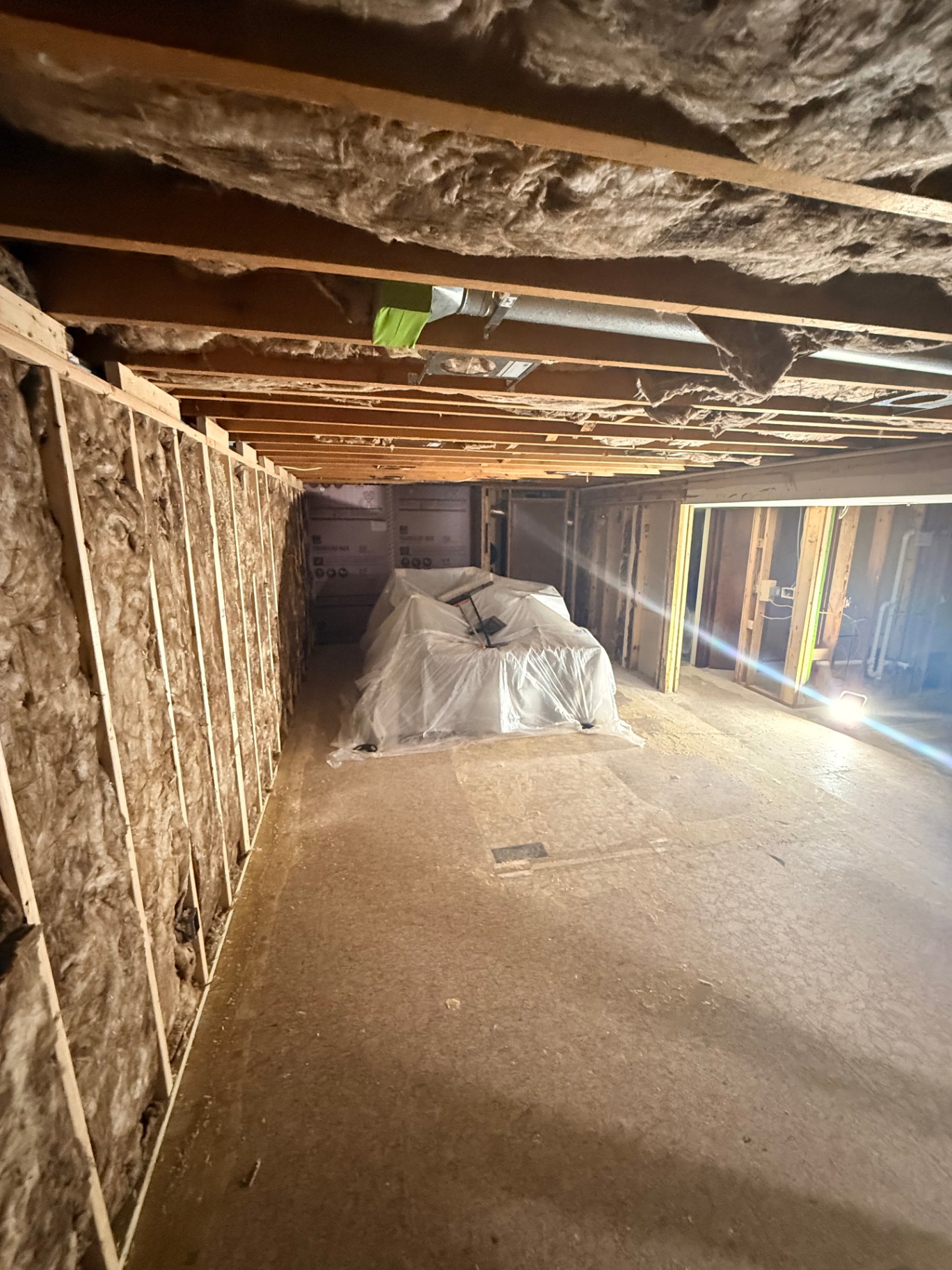 Basement opened to bare studs and joists with insulation packed between framing before board goes up