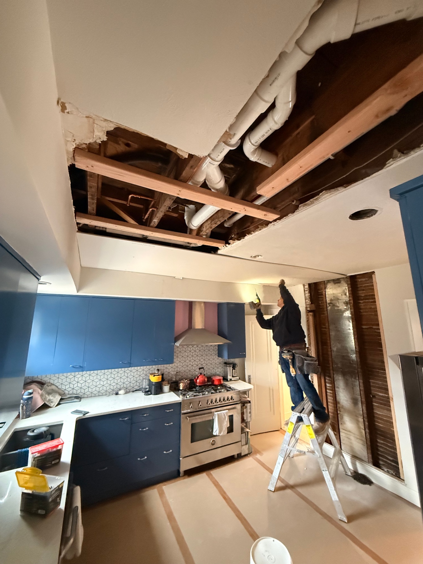 Kitchen ceiling with new framing and plumbing fully exposed before drywall goes back up