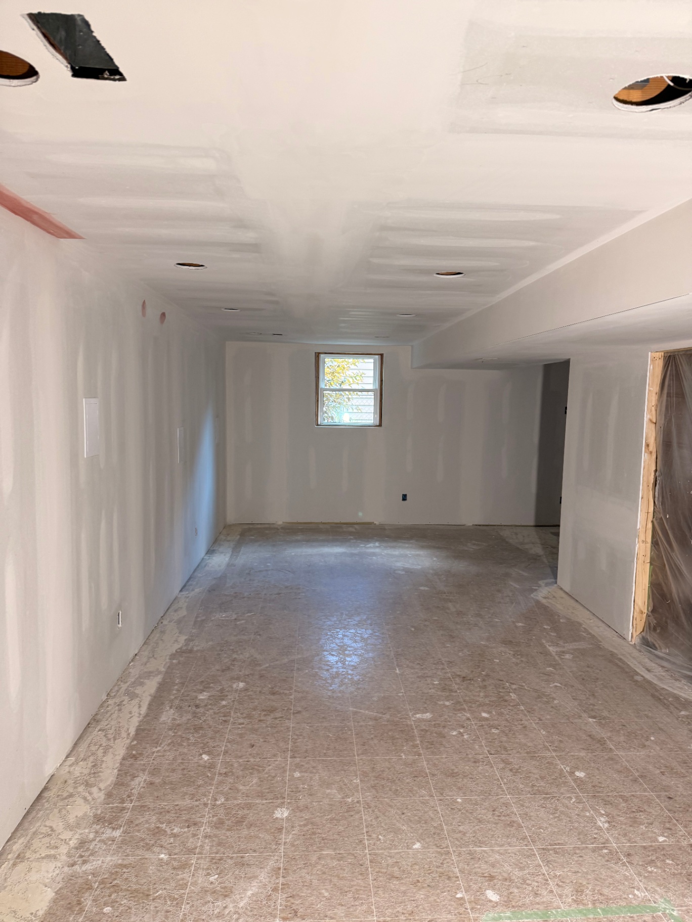 Basement main room sanded smooth with clean corners around the egress window
