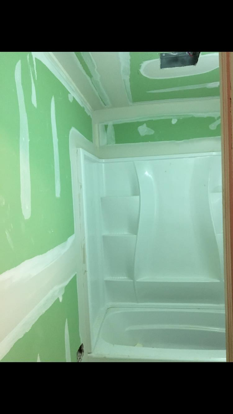 Tighter angle on the rebuilt shower wall with moisture-resistant board hung tight to the new tub surround