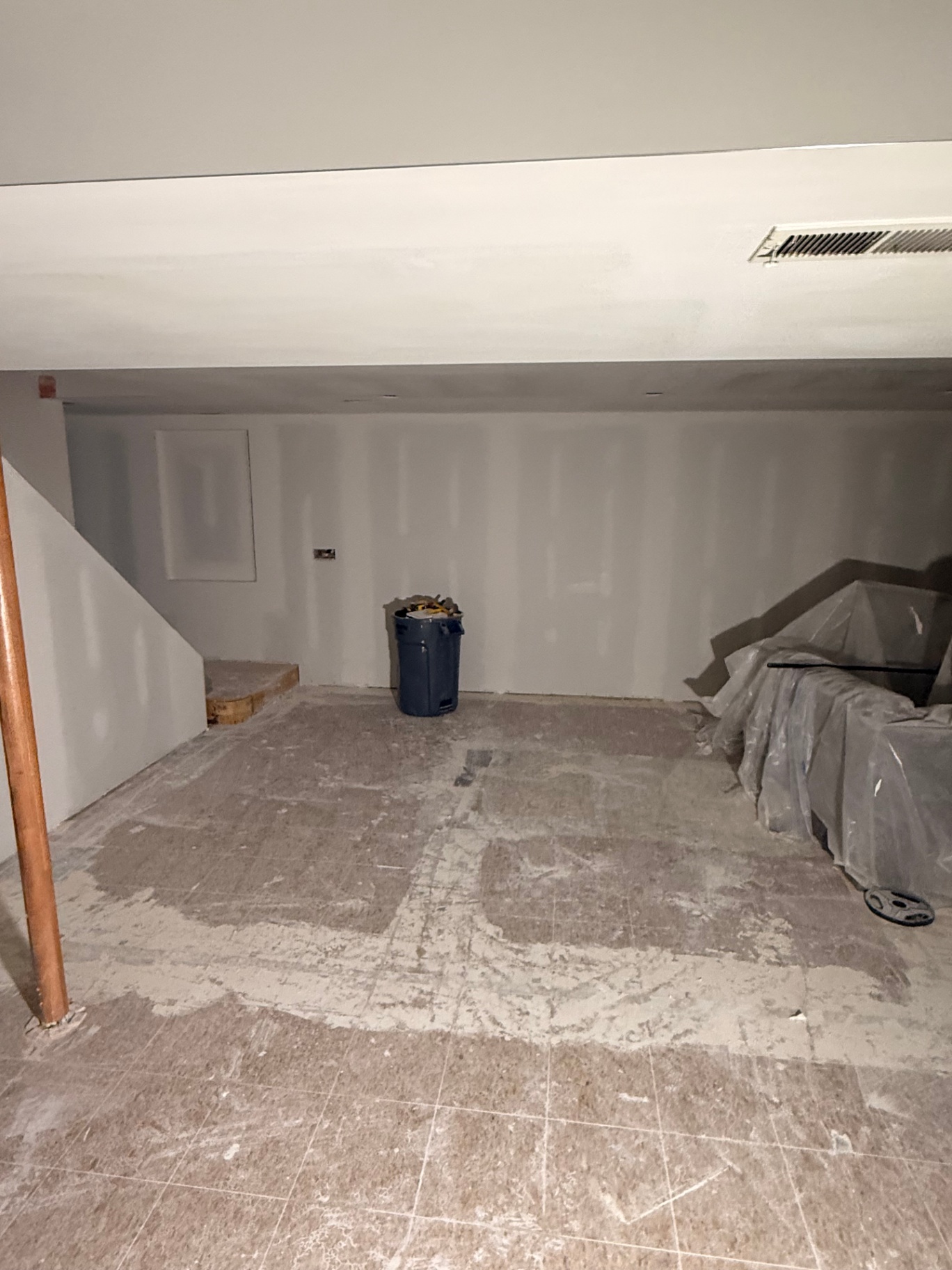 Finish coats sanded flat around the stair landing and utility wall — paint-ready surface