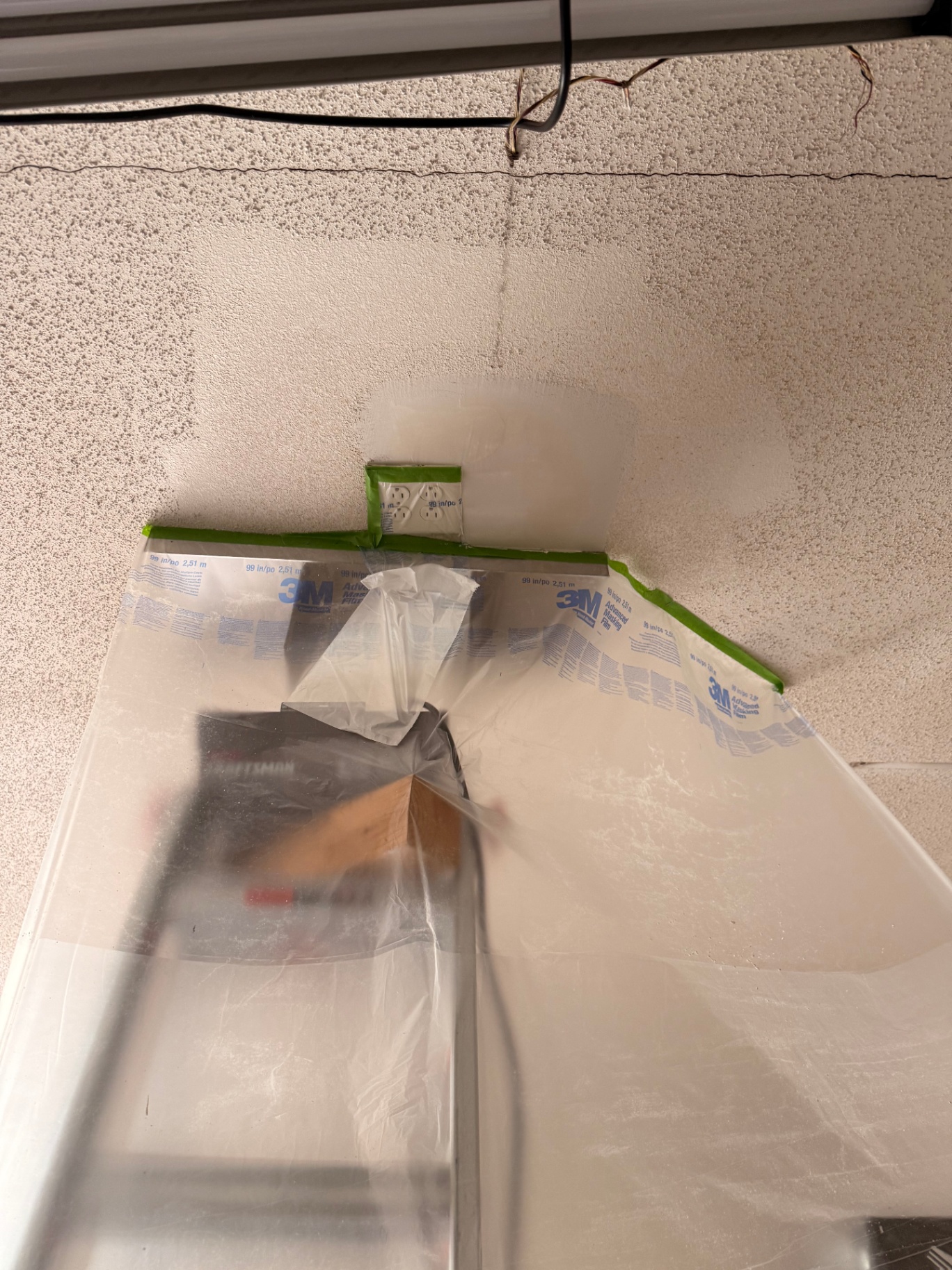 Popcorn ceiling masked off and prepped before patching around junction boxes