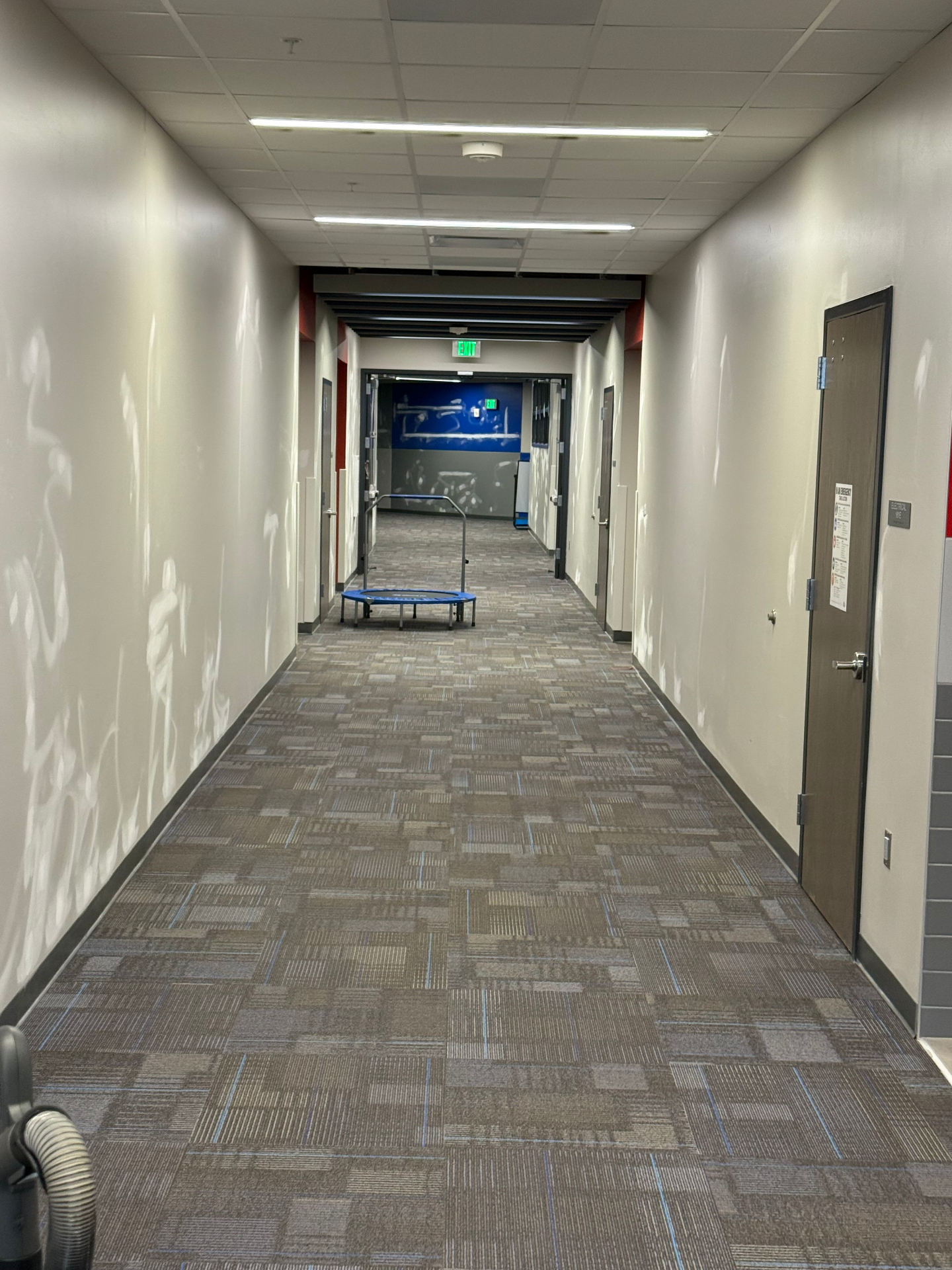 Commercial corridor walls spot-patched and feathered out down the full length — ready for paint touch-up