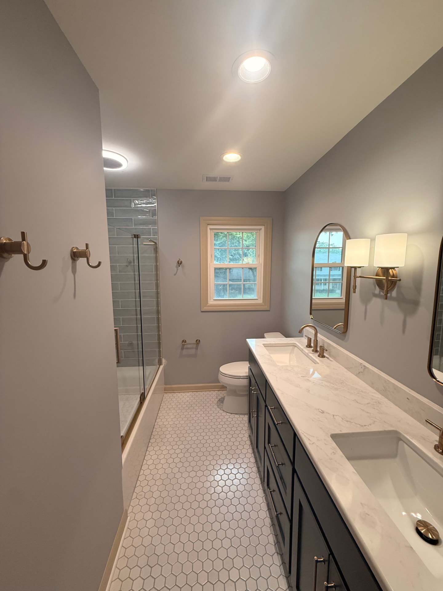 Finished bathroom — smooth painted walls and ceiling, tiled tub/shower surround, and new vanity in place