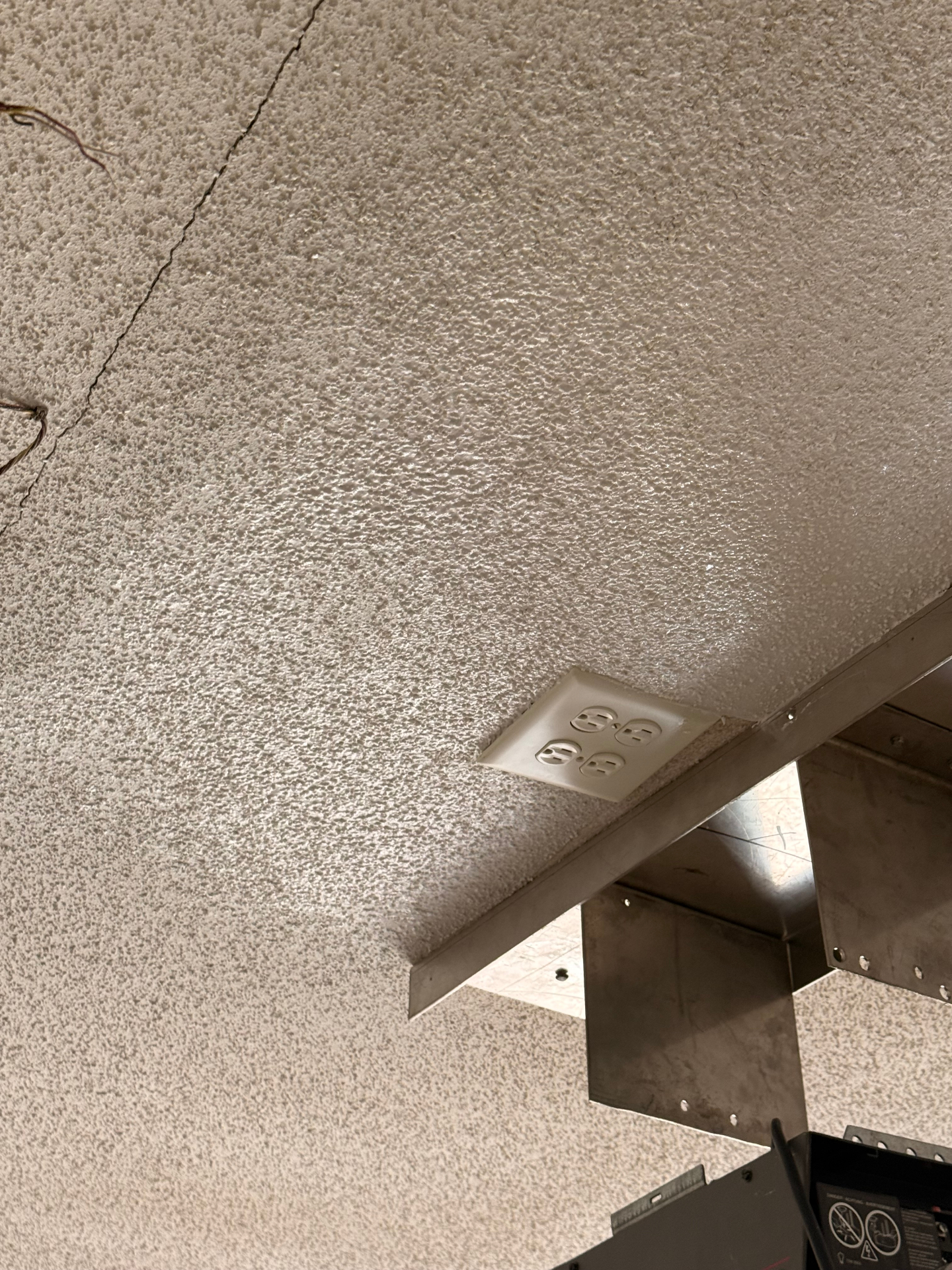 Textured ceiling repaired around an electrical box in a utility area