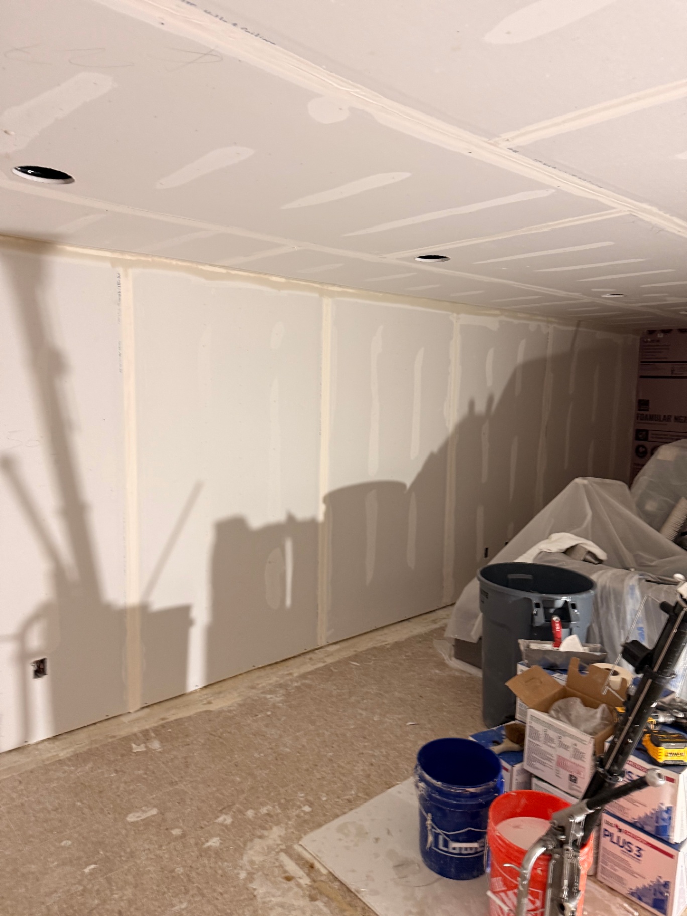 Long basement wall taped and first-coated over every seam and fastener