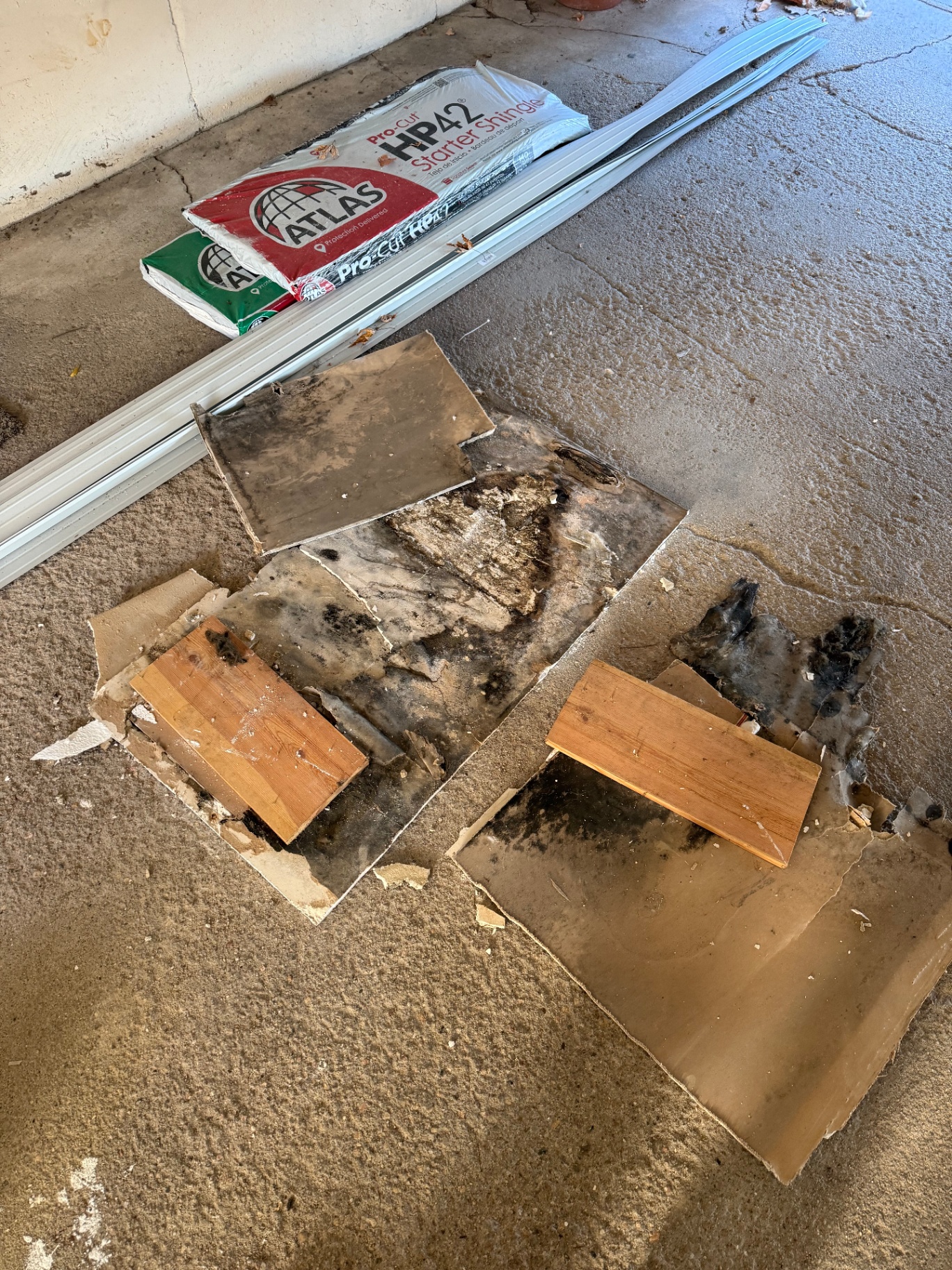 Damaged ceiling material removed and replacement board and metal corner trim staged on site before patching