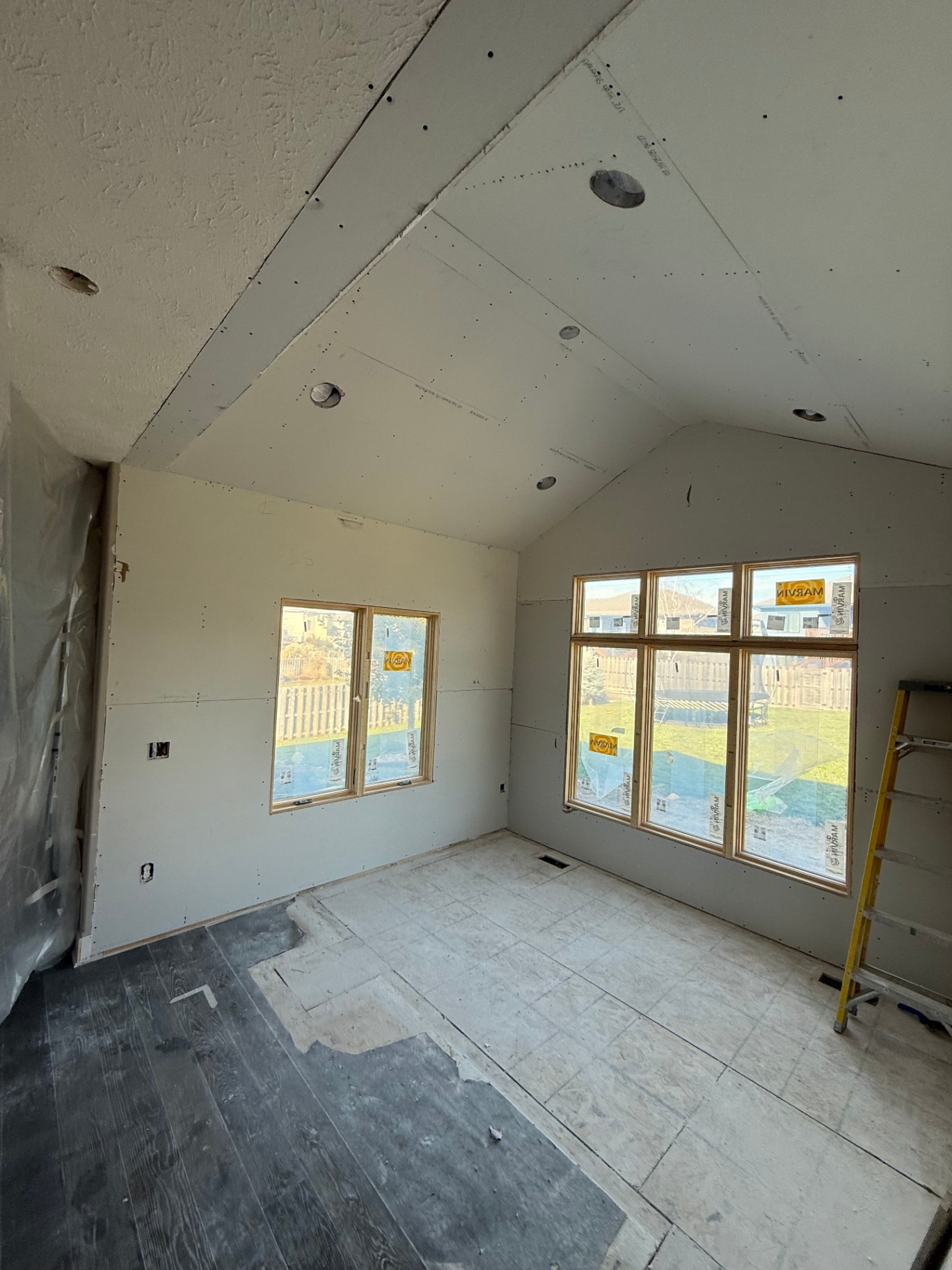 Drywall hung on the vaulted ceiling and walls — seams laid out for tape and mud