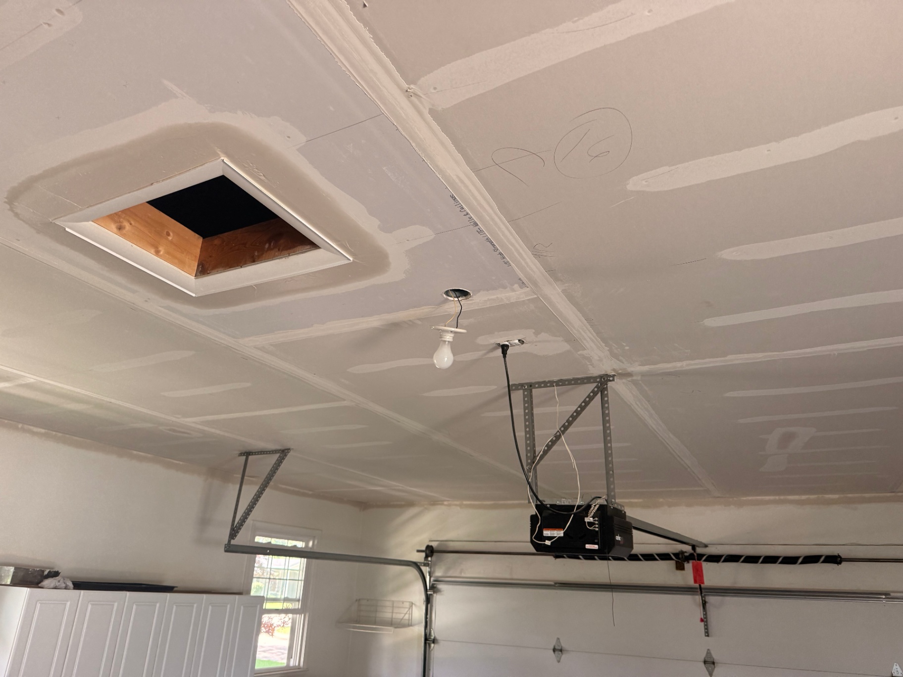 Ceiling fully hung around the attic access opening — fresh board ready for tape and mud