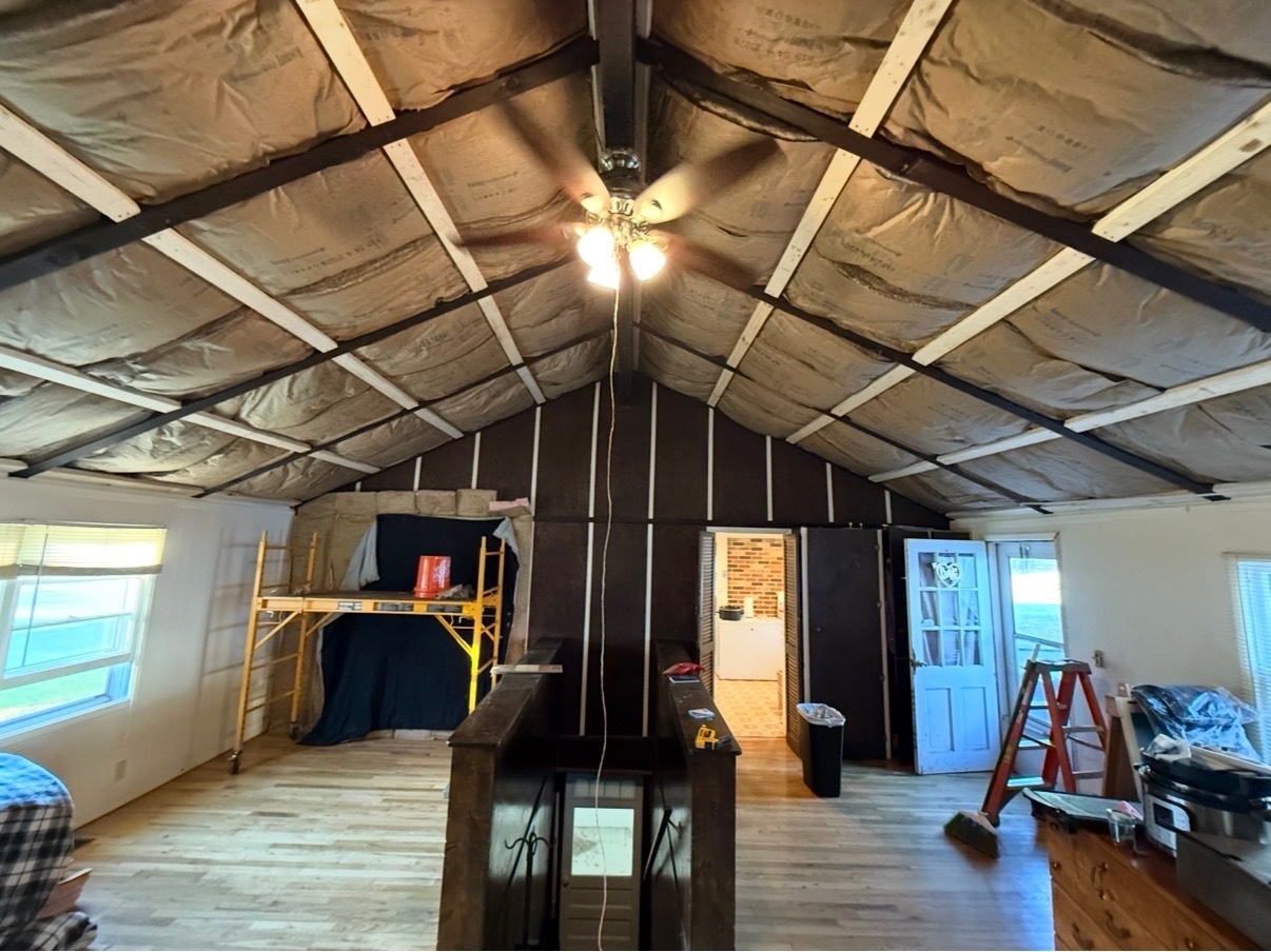 Cabin interior — vaulted ceiling framing and insulation prepped for board