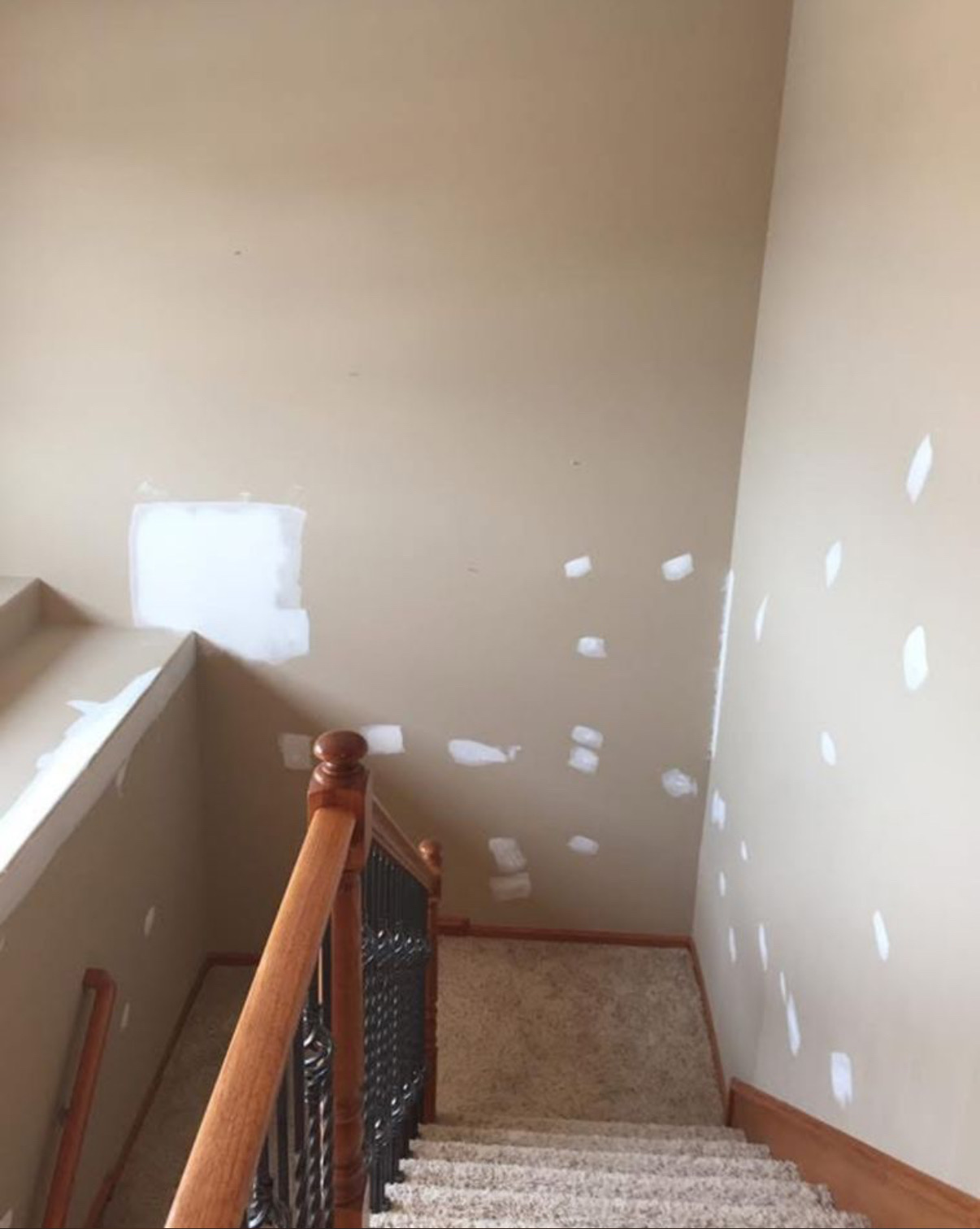Tall stairwell with multiple patches mudded ahead of paint